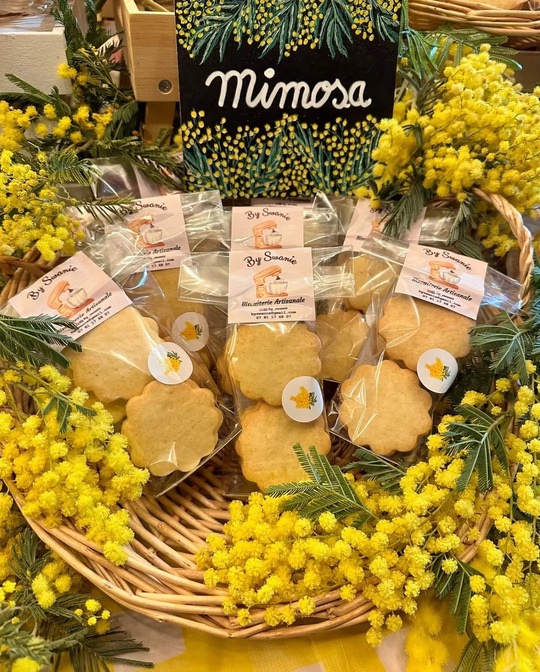 Grands biscuits sablés en sachets transparents dans un panier de mimosa